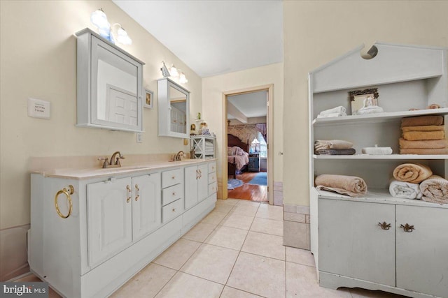 bathroom with tile patterned flooring, a sink, connected bathroom, and double vanity