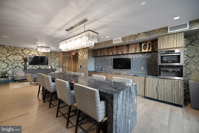 kitchen featuring visible vents, open shelves, light wood-style flooring, and wallpapered walls