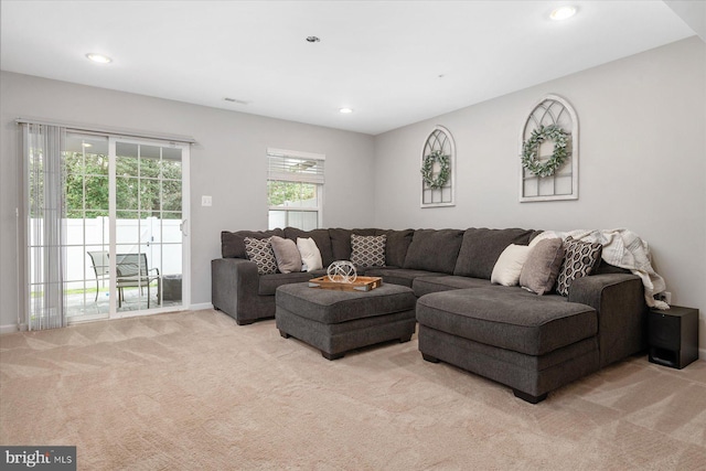 living room featuring recessed lighting, light colored carpet, and baseboards