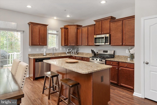 kitchen with dark wood finished floors, a breakfast bar, a sink, and appliances with stainless steel finishes