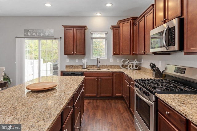 kitchen featuring a sink, dark wood-style floors, light stone counters, and stainless steel appliances