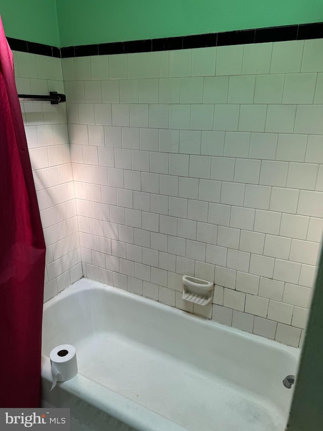 bathroom with shower / bath combo with shower curtain