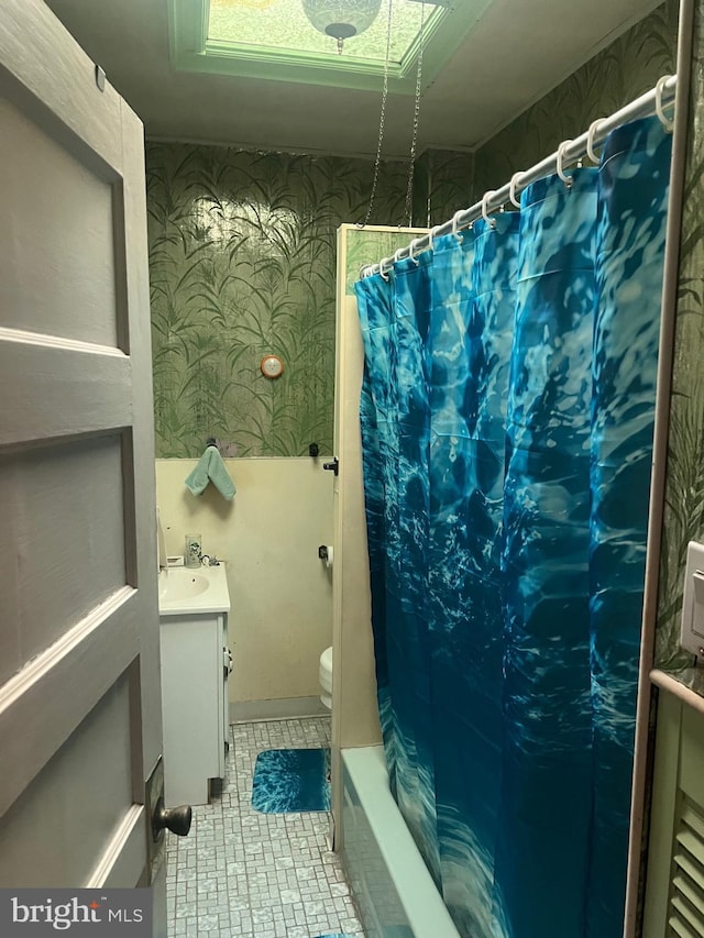 full bathroom featuring wallpapered walls, toilet, and vanity