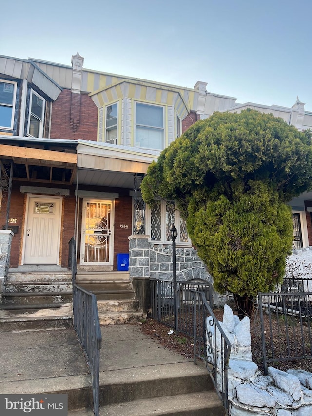 multi unit property featuring covered porch and fence