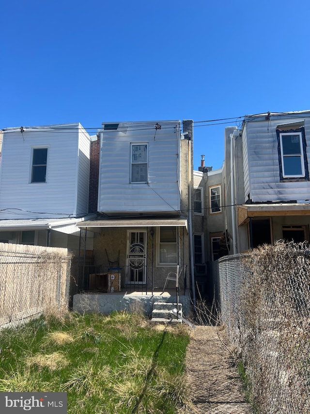 rear view of property featuring fence