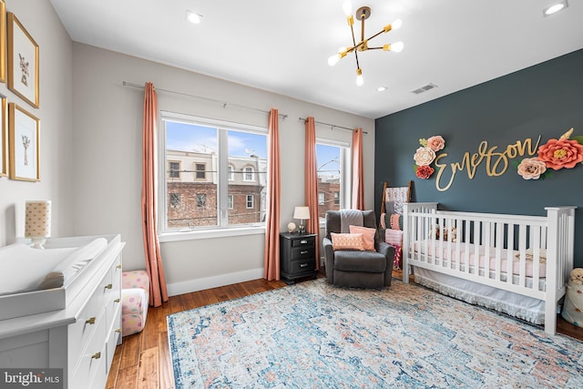 2650 E Huntingdon St, Philadelphia, PA 19125 - bedroom with visible vents, baseboards, a notable chandelier, a crib, and light wood-style flooring