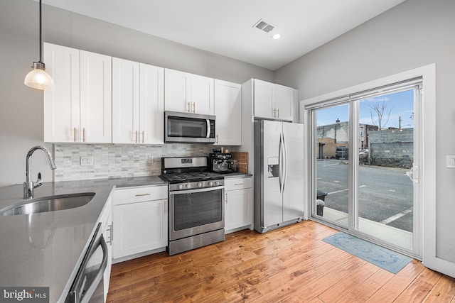 2650 E Huntingdon St, Philadelphia, PA 19125 - kitchen featuring light wood-style flooring, white cabinets, visible vents, stainless steel appliances, and a sink