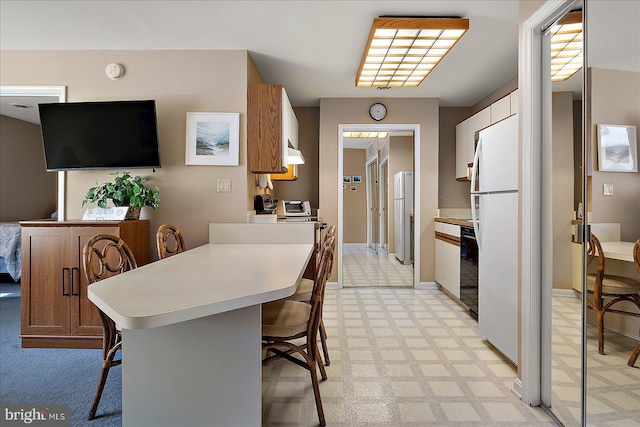 105 120th St Unit 111, Ocean City, MD 21842 - kitchen featuring a breakfast bar area, freestanding refrigerator, light countertops, and light floors