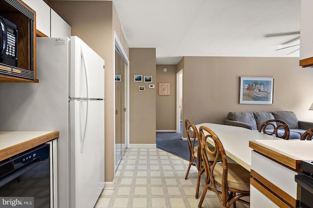 105 120th St Unit 111, Ocean City, MD 21842 - kitchen featuring white cabinets, light floors, open floor plan, baseboards, and black appliances