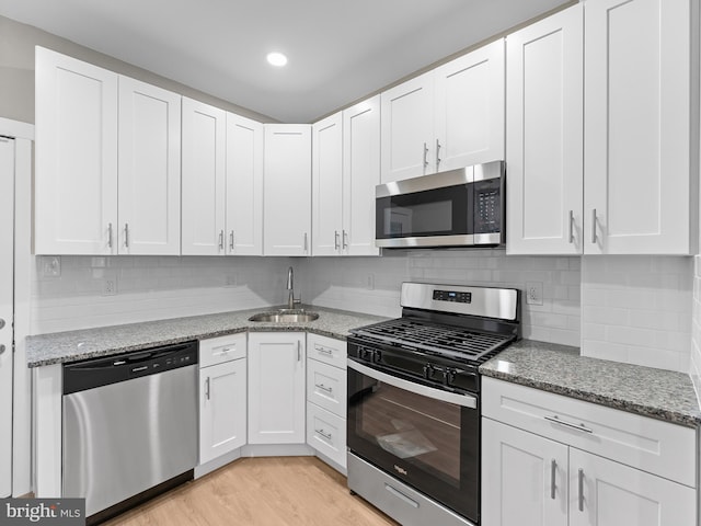 kitchen with white cabinets, stainless steel appliances, and a sink