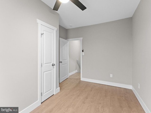 unfurnished bedroom featuring light wood-style flooring, baseboards, and a ceiling fan