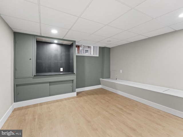below grade area featuring recessed lighting, wood finished floors, baseboards, and a paneled ceiling