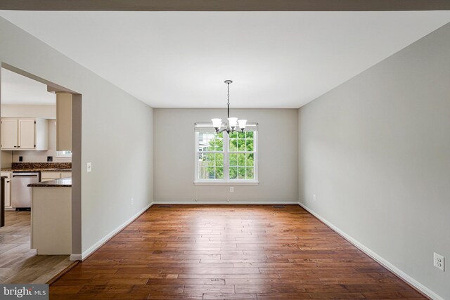 218 Foxborough Dr SW, Leesburg, VA 20175 - unfurnished dining area with an inviting chandelier, baseboards, and wood-type flooring