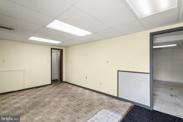 empty room with a drop ceiling and baseboards