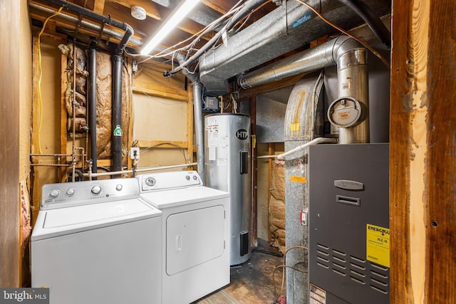 clothes washing area featuring electric water heater and washer and dryer