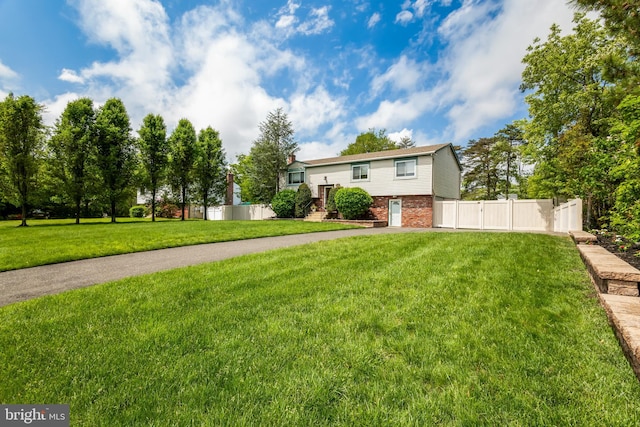bi-level home featuring brick siding and a gate