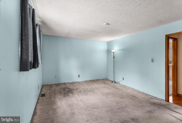 unfurnished room featuring carpet floors and a textured ceiling