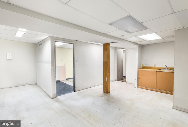 finished below grade area featuring light flooring and a sink