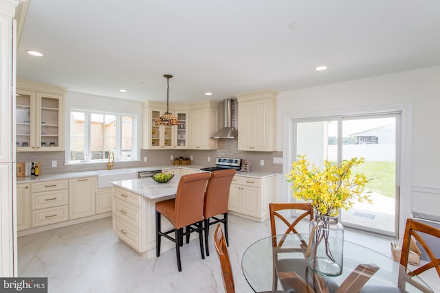 1948 Forest Grove Rd, Furlong, PA 18925 - kitchen with wall chimney exhaust hood, cream cabinetry, stainless steel appliances, a sink, and a kitchen bar