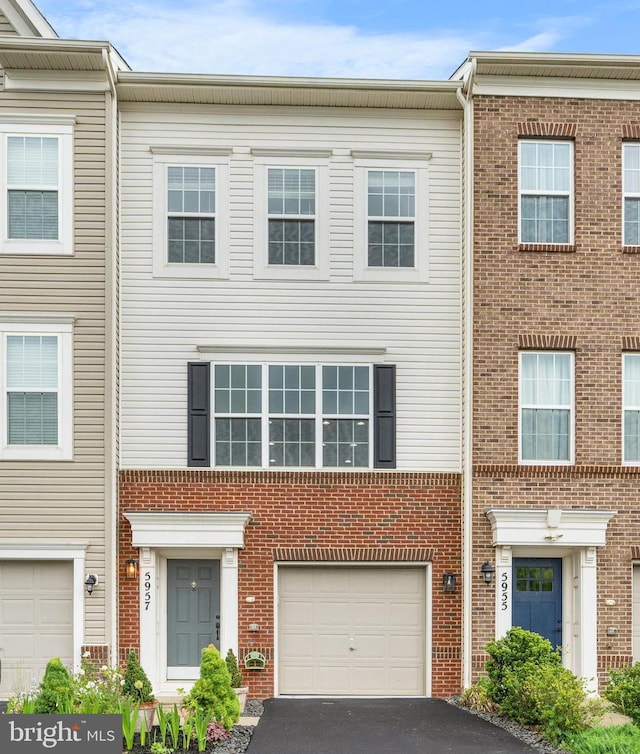 5957 Whelan Ln, Frederick, MD 21703 - townhome / multi-family property featuring a garage, driveway, and brick siding