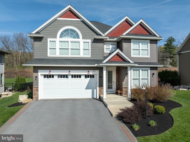 view of front of house featuring an attached garage, driveway, a shingled roof, and stone siding