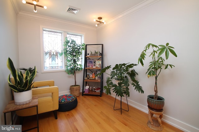 living area with crown molding, baseboards, and wood finished floors