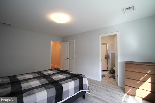 bedroom with visible vents, connected bathroom, light wood-style floors, and baseboards