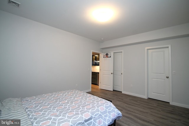 bedroom featuring visible vents, baseboards, and wood finished floors