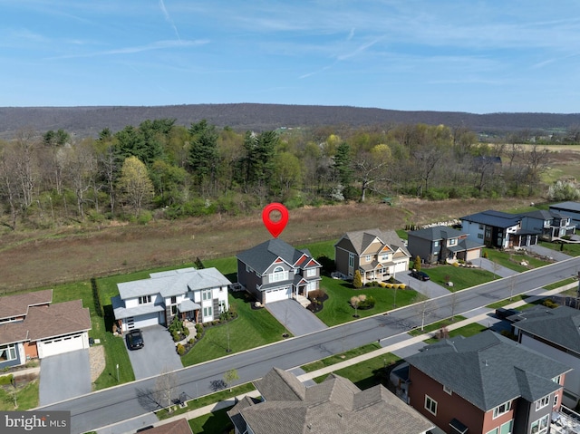 birds eye view of property featuring a residential view and a wooded view