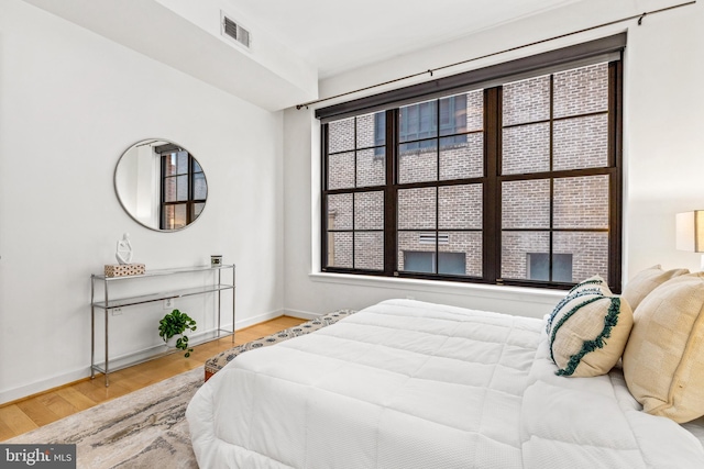 2412 17th St NW Unit 102, Washington, DC 20009 - bedroom featuring wood finished floors, baseboards, and multiple windows