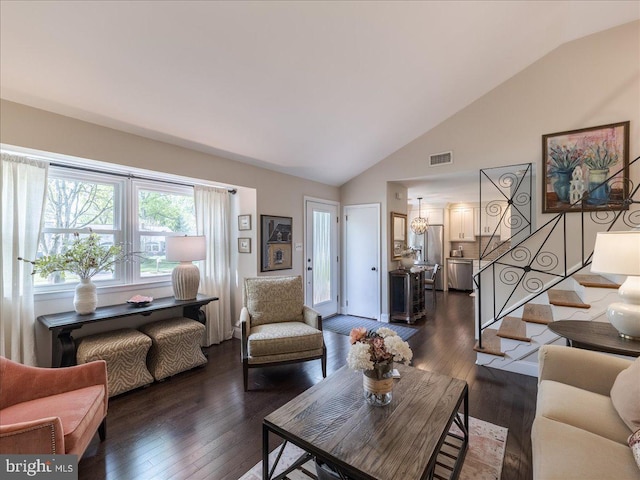 living room with stairs, dark wood-style floors, a chandelier, and high vaulted ceiling