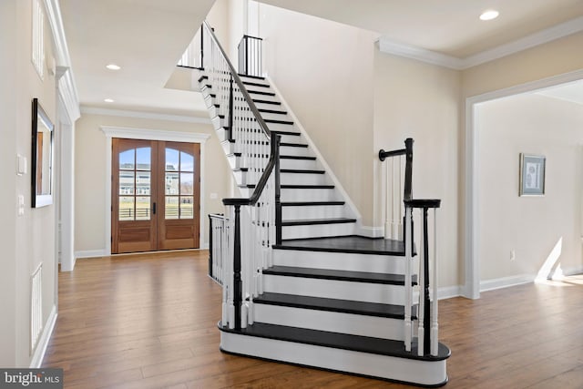 foyer entrance featuring crown molding, stairway, french doors, recessed lighting, and hardwood / wood-style floors