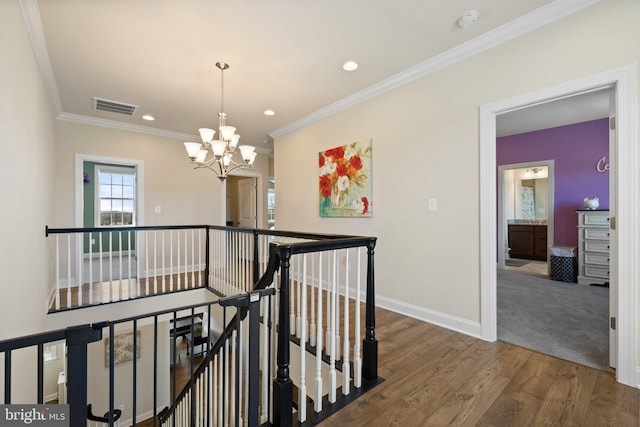 hallway featuring an upstairs landing, baseboards, a chandelier, visible vents, and wood finished floors