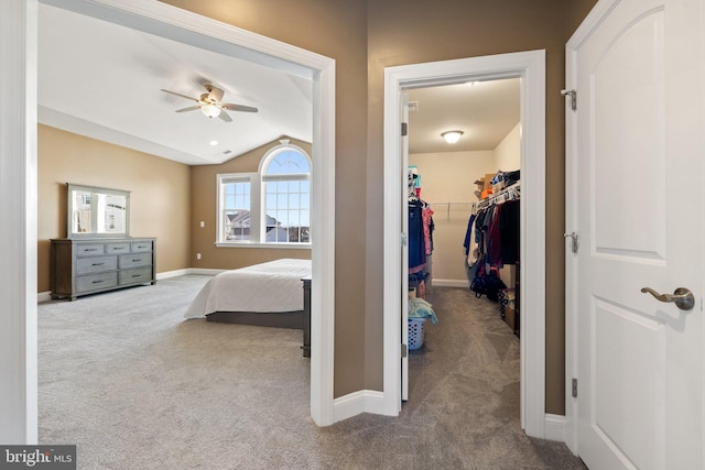 bedroom with a closet, baseboards, carpet floors, vaulted ceiling, and a spacious closet