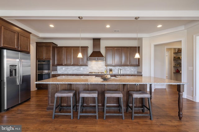 kitchen with decorative backsplash, premium range hood, dark wood finished floors, appliances with stainless steel finishes, and light stone counters