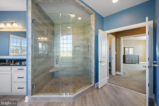 full bath featuring baseboards, vanity, and a shower stall