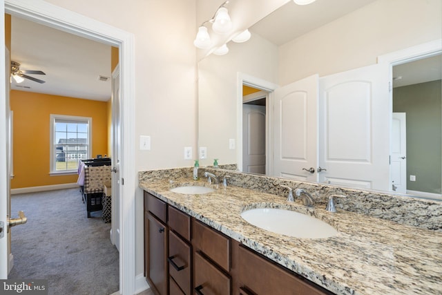 full bathroom featuring baseboards, double vanity, a sink, and a ceiling fan