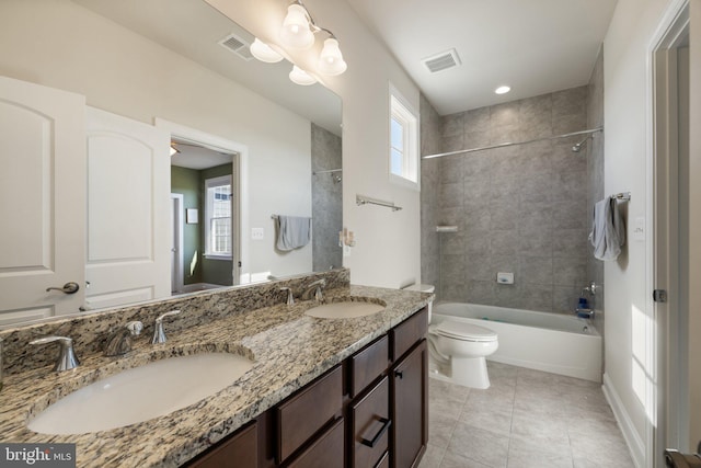 bathroom with visible vents, a sink, toilet, and double vanity