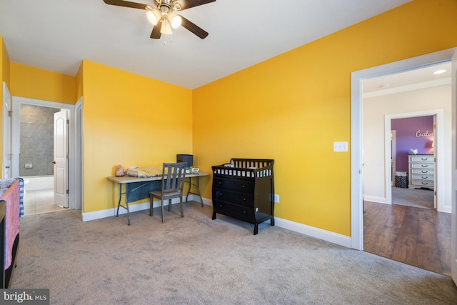 carpeted office space featuring a ceiling fan and baseboards