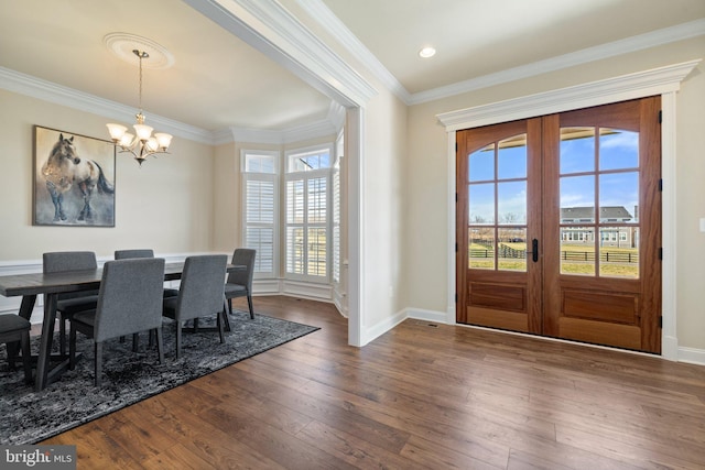 dining room featuring crown molding, french doors, a chandelier, baseboards, and dark wood-type flooring