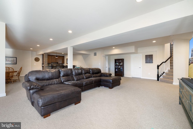 carpeted living area featuring baseboards, visible vents, recessed lighting, and stairway