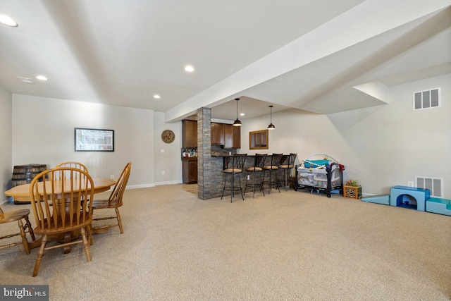 dining space featuring light carpet, visible vents, recessed lighting, and bar
