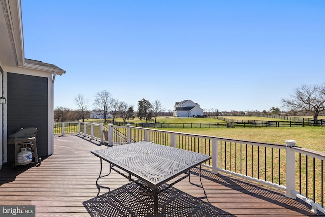 deck with fence, a rural view, and a yard