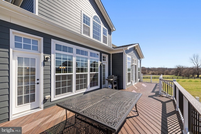 deck with a grill and outdoor dining space