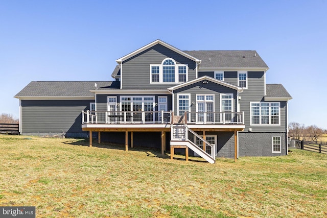 rear view of property with stairs, a lawn, fence, and a wooden deck