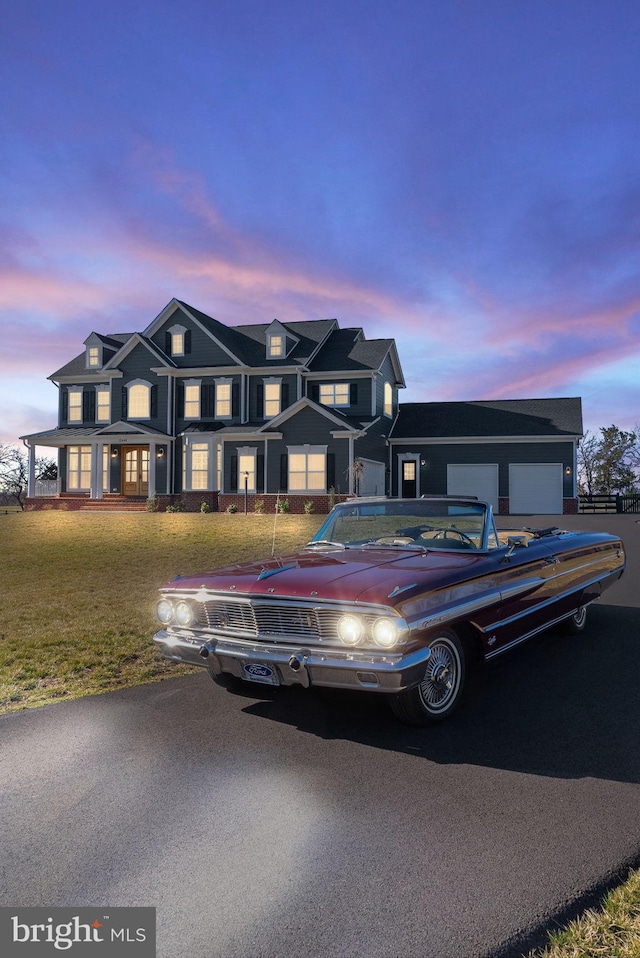 view of front of house featuring driveway, a garage, and a front lawn