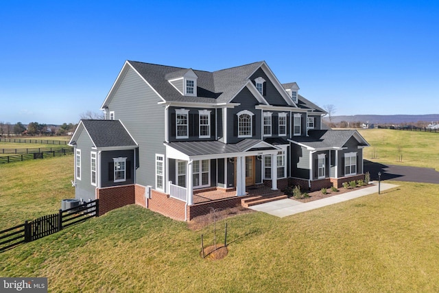 view of front of house featuring cooling unit, a front yard, fence, and brick siding
