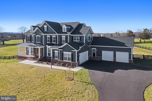 view of front of home with aphalt driveway, fence, an attached garage, brick siding, and a front lawn