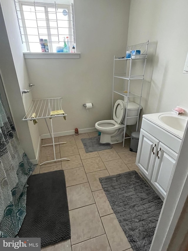 full bathroom with tile patterned floors, toilet, vanity, and baseboards