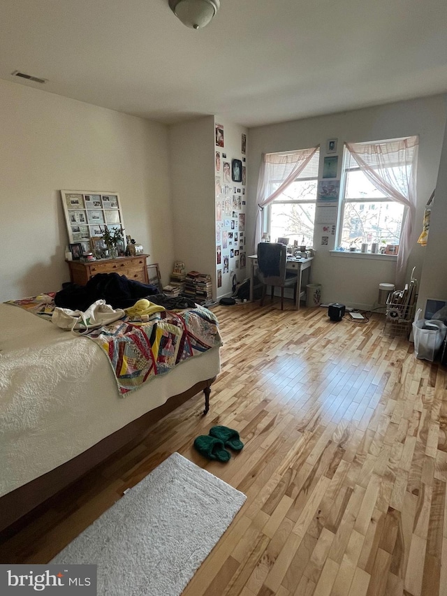 bedroom featuring visible vents and wood finished floors